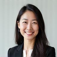 Yumi Tanaka, Head of Customer Support at Akatsuki Ryoko, a professional Japanese woman smiling warmly